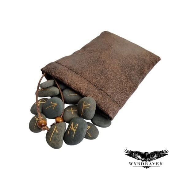 Elder Futhark River Stone Runes tumbling out of a brown, faux leather pouch - Viking Runes - Wyrdraven Runes - wyrdraven.co.uk